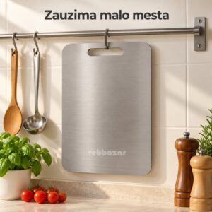 Metalna daska za sečenje okačena o kuku na zidnoj šipki u kuhinji